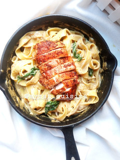 A picture of Chicken fettuccine pasta in white sauce.
