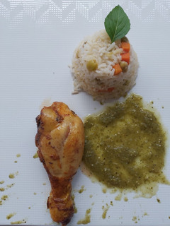 Una foto de Pierna de pollo al horno con salsa verde y guarnición de arroz
