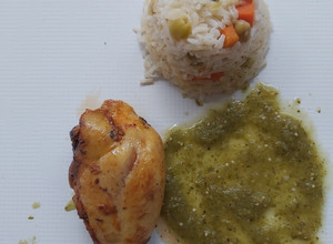 Una foto de Pierna de pollo al horno con salsa verde y guarnición de arroz