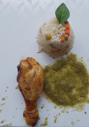 Una foto de Pierna de pollo al horno con salsa verde y guarnición de arroz