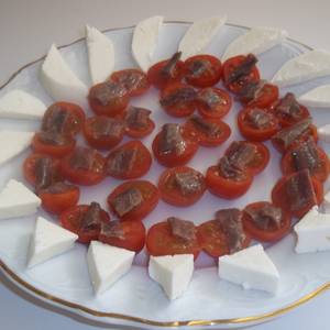 Rueda de tomates cherry, anchoas y queso de servilleta