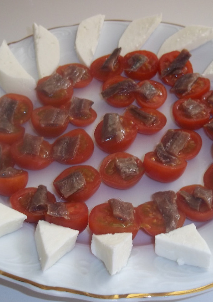 Una foto de Rueda de tomates cherry, anchoas y queso de servilleta