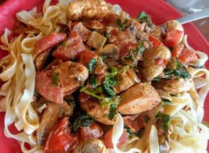 Una foto de Fideos con pollo, tomate y champignones