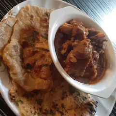 A picture of Garlic naan bread with lamb soup.