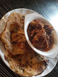 A picture of Garlic naan bread with lamb soup.