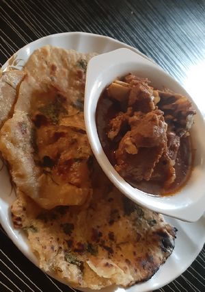 A picture of Garlic naan bread with lamb soup.