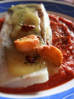 Una foto de Bacalao confitado con salsa de tomate cubierto de su Pil Pil