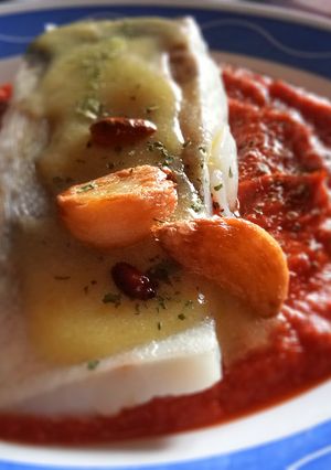 Una foto de Bacalao confitado con salsa de tomate cubierto de su Pil Pil
