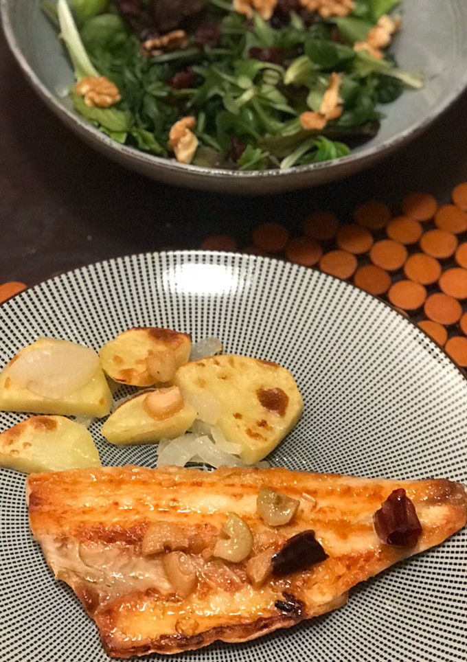 Una foto de Lubina a la plancha con refrito de ajos, patatas panaderas y lechugas variadas