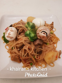 A picture of Jollof spaghetti with mushrooms and broccoli.