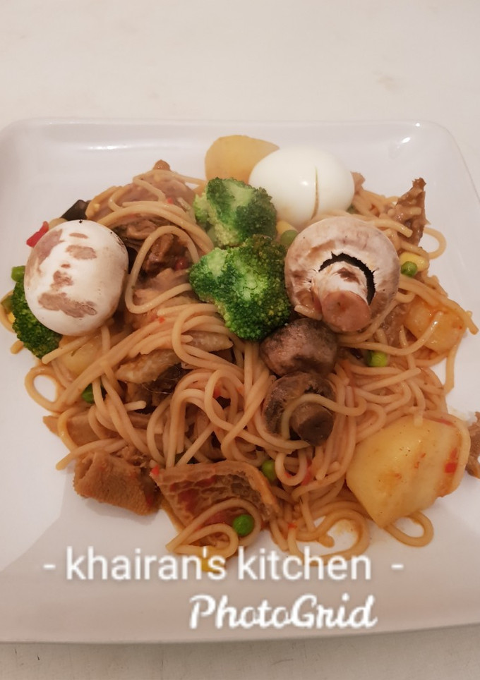 A picture of Jollof spaghetti with mushrooms and broccoli.