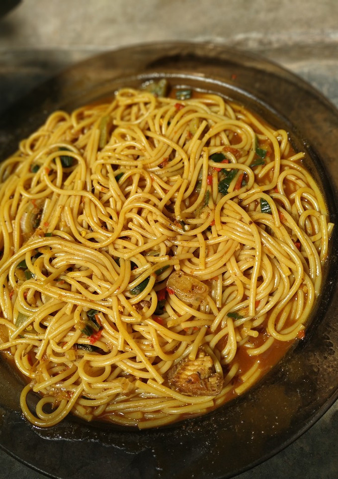 A picture of Local spaghetti jollof with Locust beans.