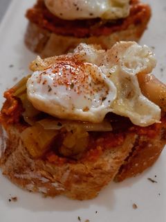 Una foto de Pincho de calçots en escabeche, romesco y huevo de codorniz