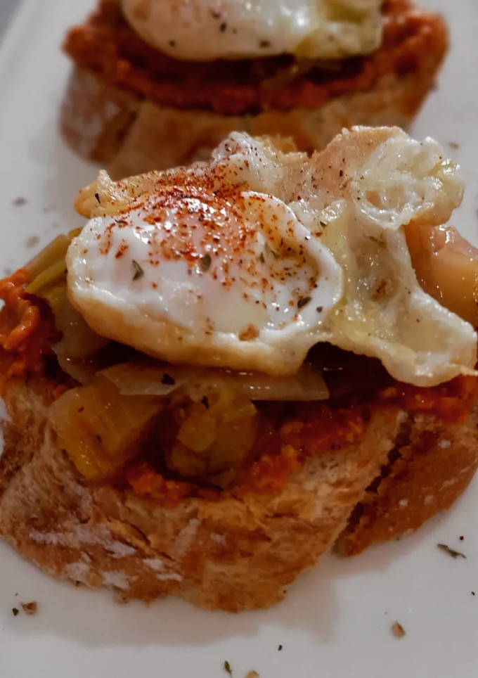 Una foto de Pincho de calçots en escabeche, romesco y huevo de codorniz