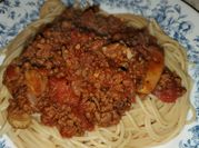 A picture of spaghetti sauce with bell peppers and mushrooms