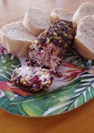 Una foto de Rollo de queso con arándanos, pistachos, panceta y miel