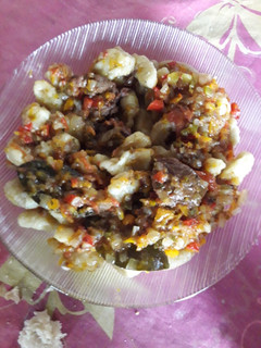 Una foto de Ñoquis de papas con salsa y carne