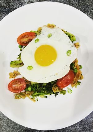 A picture of Avocado and basil red lentil pasta with a crispy fried egg.