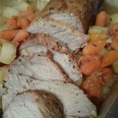 A picture of Pork loin with roasted apples and carrots.