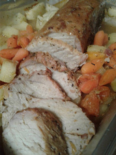 A picture of Pork loin with roasted apples and carrots.