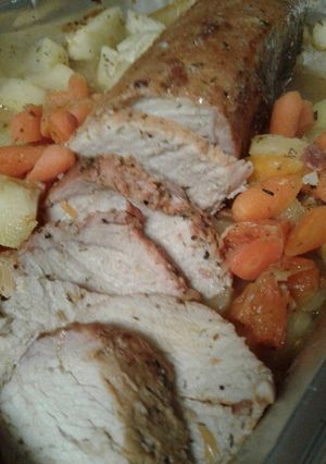 A picture of Pork loin with roasted apples and carrots.