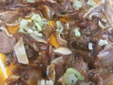 Oreja de cerdo sobre brava y cebollita japonesa
