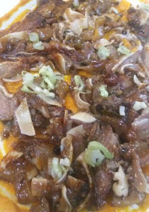 Una foto de Oreja de cerdo sobre brava y cebollita japonesa