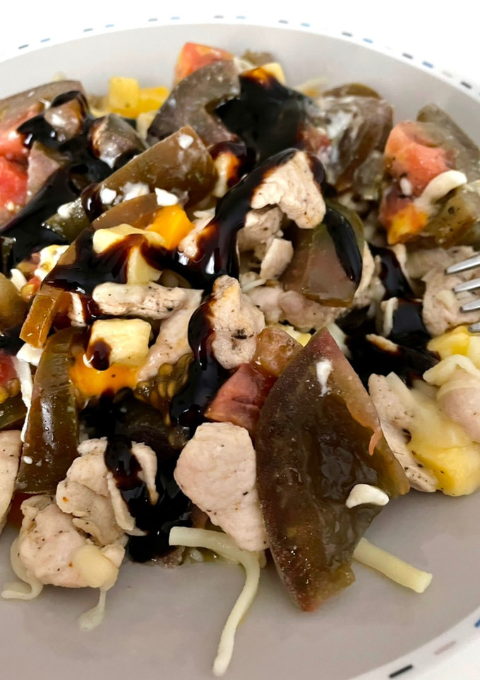 Una foto de Ensalada de tomate con pollo y queso