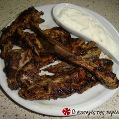 A picture of Lamb chops in lemon with a yogurt sauce.