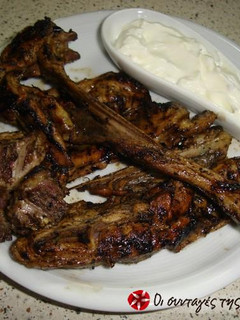 A picture of Lamb chops in lemon with a yogurt sauce.