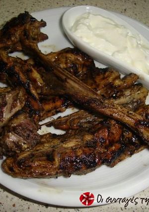 A picture of Lamb chops in lemon with a yogurt sauce.