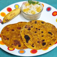 A picture of Dashmi -- Milk Based Flatbread With Sweet Elaichi Kela & Sev Raita.