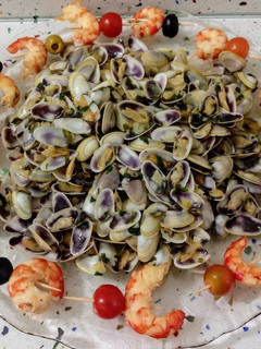 Una foto de Coquinas al ajillo y pinchitos de langostinos a la plancha