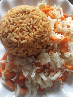 A picture of Jollof rice with cabbage and carrots.
