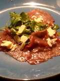Carpaccio de ternera con brotes tiernos de rúcula y parmesano