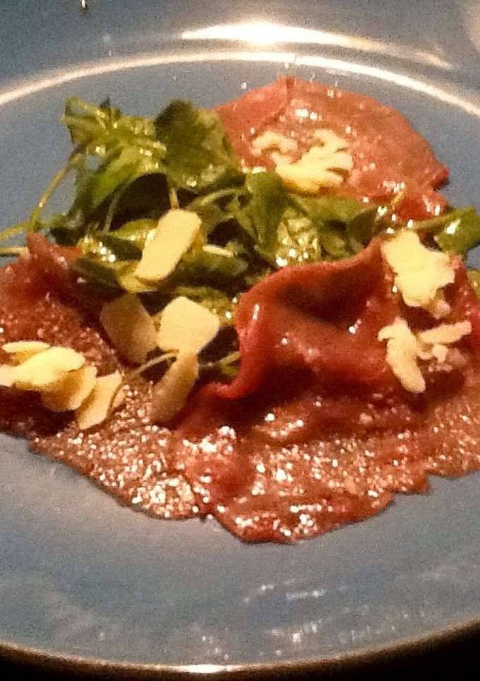 Una foto de Carpaccio de ternera con brotes tiernos de rúcula y parmesano
