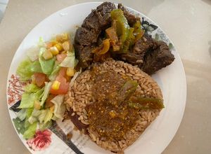 Una foto de Churrasco en salsa criolla, arroz con consomé y ensalada