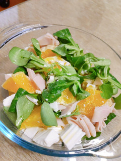 Una foto de Ensalada de canónigos, naranja, queso y pavo