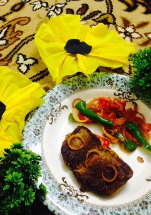 A picture of Fried Beef steak with veggies.