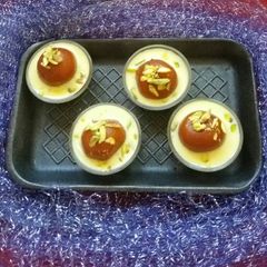 A picture of Gulab jamun with custard.