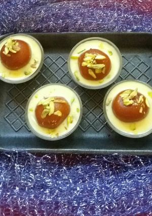 A picture of Gulab jamun with custard.