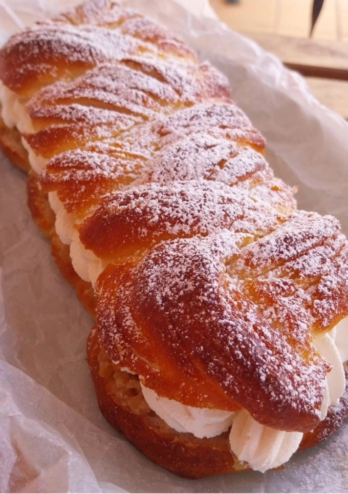 Una foto de Trenza de brioche hojaldrado rellena de manzana caramelizada con almendras y nata