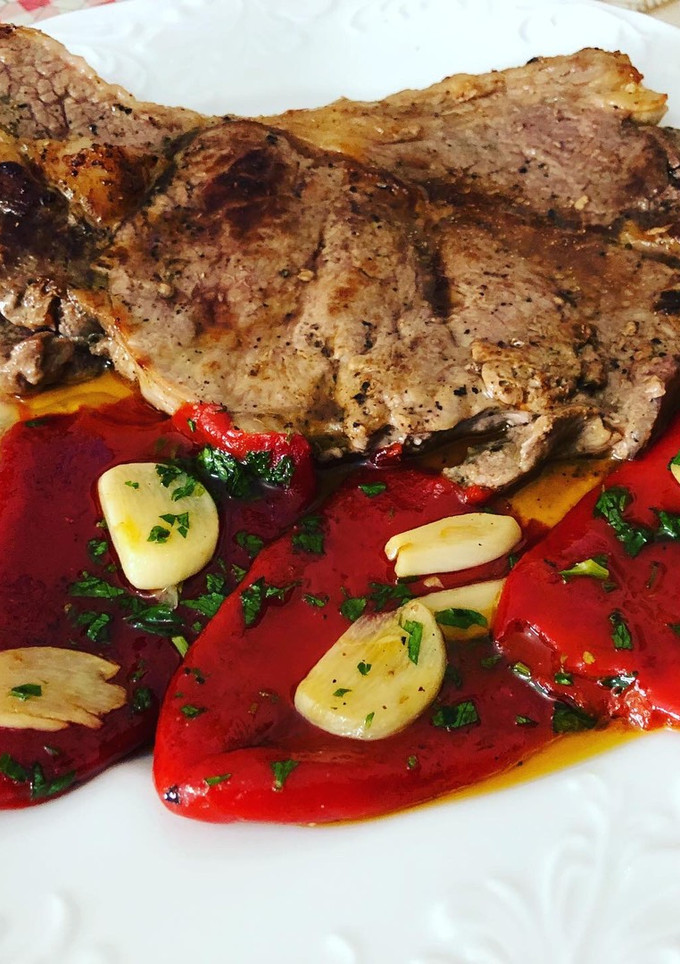 Una foto de Bistec de ternera a la plancha con guarnición de pimiento del piquillo confitados