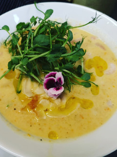 A picture of Creamy cheesy potatoes carrots soup served with shrimps.