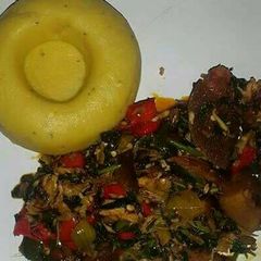 A picture of Pounded unripe plantain with assorted meat and vegetable soup.
