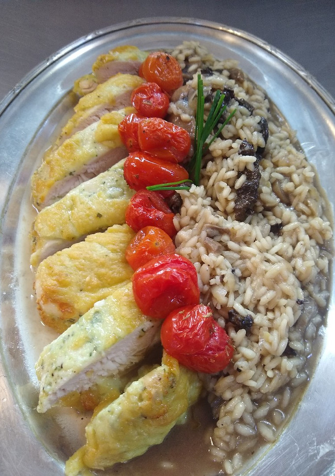 Una foto de Pollo al parmeggiano con risotto al fungi