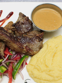 A picture of Grilled lamb, smashed potatoes and sauce.