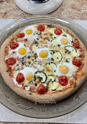Una foto de Pizza 🍕 con base de Espelta Integral mitad bacon-mitad calabacín con huevos de codorniz 🍳