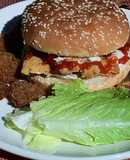 Hamburguesa de pescado estilo Sitka Alaska con guarnición de aros de cebolla y pepinillos fritos