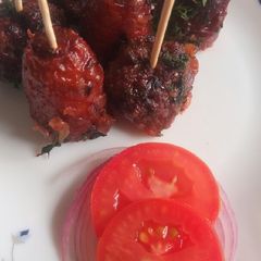 A picture of Meat balls and beef sausages bitings in sauce.